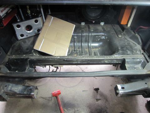 2008 Jeep Wrangler - The rear section of a vehicle is shown with the fuel tank removed, revealing the undercarriage and suspension components.