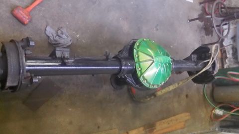1979 Ford Bronco - A rear axle assembly is shown with a bright green differential cover, likely part of a vehicle modification or repair.