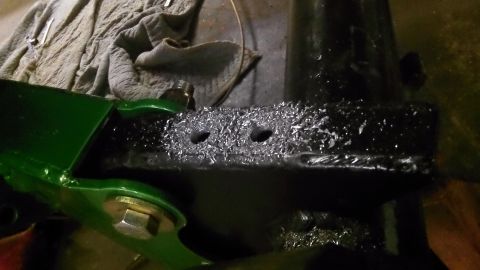 1979 Ford Bronco - A close-up view of a metal bracket with fresh drill shavings, suggesting recent modification or repair.