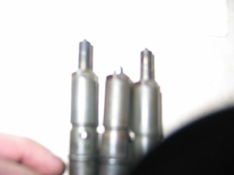 1984 Ford Bronco - Close-up view of three diesel fuel injectors, likely for a vehicle engine.