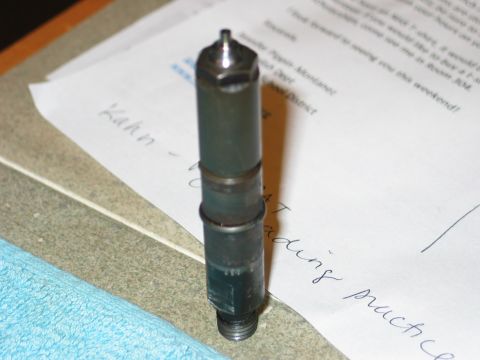 1984 Ford Bronco - A diesel injector part is shown resting on papers with handwritten notes and a blue cloth.