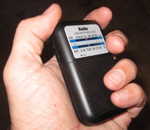 1990 Ford Bronco - A Kaito KA200 portable radio is held in a person's hand, showing the AM and FM frequency bands.