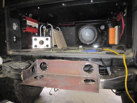 2008 Jeep Wrangler - The rear of a vehicle is shown with a custom-fabricated bumper and installed audio equipment, including a subwoofer and power inverter.