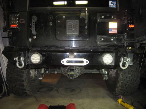 2008 Jeep Wrangler - The rear of a modified Jeep shows an aftermarket bumper with a winch, tow hooks, and auxiliary lights.