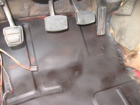 1981 Ford Bronco - Interior view of vehicle floor with pedals and exposed wiring.