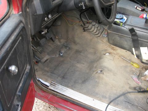 1981 Ford Bronco - Interior view of a 1981 Ford Bronco, showing the floor, pedals, shifter, and dashboard, likely during a repair or maintenance process.