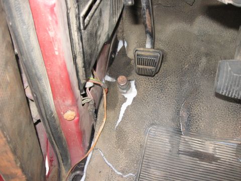1981 Ford Bronco - Close-up view of the driver's side floor area, showing pedals and exposed wiring near the door jamb.