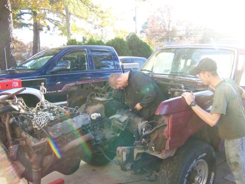 1985 Ford Bronco - Two men work on the engine of a 1985 Ford Bronco during an engine swap.