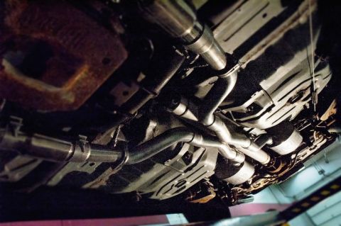 1998 Ford Crown Victoria - Underside view of a vehicle's exhaust system with dual mufflers and polished pipes.