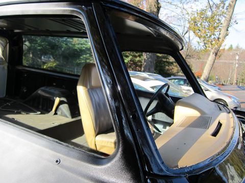 1987 Dodge 1500 - The interior of a pickup truck is shown, with a view of the dashboard and seats, and another vehicle in the background.
