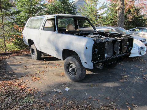 1987 Dodge 1500 - This unfinished SUV, likely from the 1980s, sits in an outdoor lot with its front end disassembled.