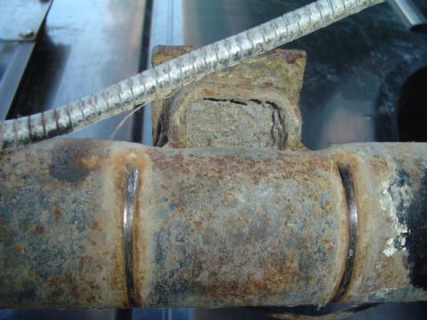 1993 Ford Bronco - Close-up view of a rusted rear axle housing and brake line, showing signs of wear and corrosion.