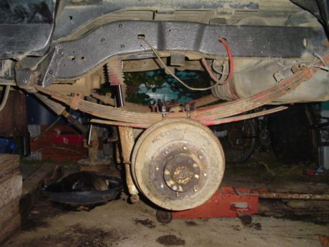 1993 Ford Bronco - The rear suspension and axle assembly of a vehicle are visible, undergoing maintenance or repair.
