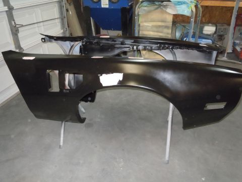 1973 Pontiac Trans Am - Car body parts, a fender and hood, are prepped for work in a garage setting.