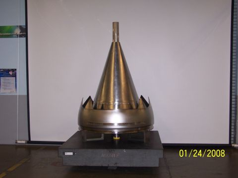 1992 Ford Taurus - A metallic cone, possibly part of a jet engine, is displayed on a stand with a date stamp in the corner.