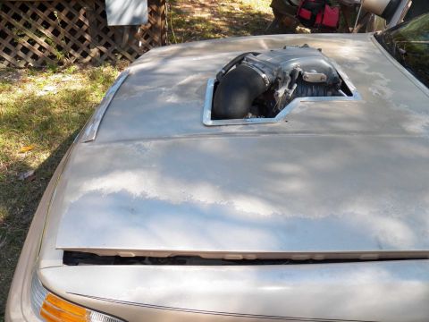 1993 Ford Crown Victoria - A car's hood has been modified with a large opening to accommodate an engine intake system.