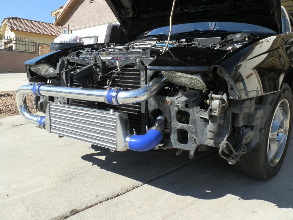 car front end with hood open, showing intercooler and piping installed