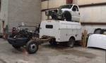 1994 Ford Probe - Truck chassis and cab are stacked on a utility trailer in a workshop.