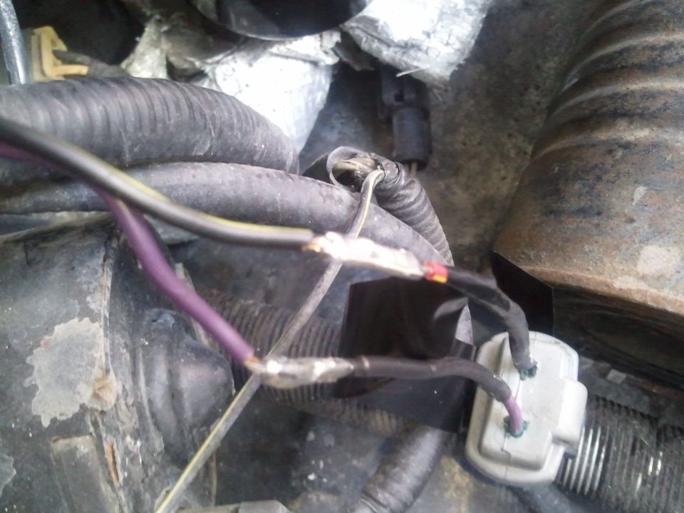 Close-up of engine wiring with purple and black wires connected with crimp connectors