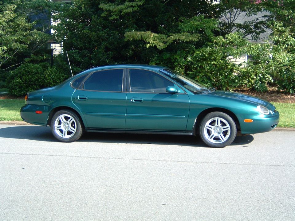 1997 Ford Taurus sedan, side view, green paint, alloy wheels