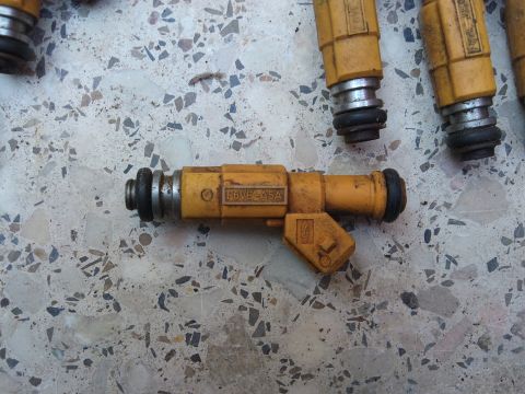 1998 Ford Crown Victoria - A close-up shows a yellow fuel injector with the part number F6VE-4A5A visible.
