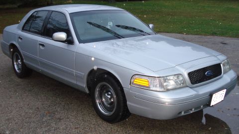 2000 Ford Crown Victoria - The front quarter view of a silver sedan shows its grille and headlights.