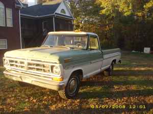 2004 Ford F-150 - A vintage Ford pickup truck with a two-tone paint scheme sits in a grassy yard near a house.