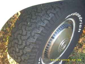 2004 Ford F-150 - Close-up view of a BFGoodrich All-Terrain T/A tire mounted on a wheel, with visible text on the tire sidewall.