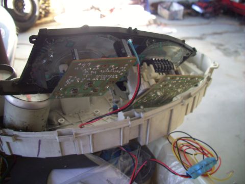 1995 Ford Probe - The internal components of a car's instrument cluster are exposed, showing circuit boards and wiring.