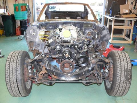 1976 Chevrolet Corvette - Front view of a 1976 Chevrolet Corvette chassis with its engine installed, undergoing restoration.