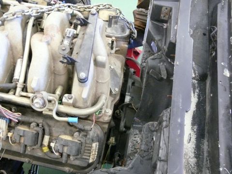 1976 Chevrolet Corvette - Close-up view of a V8 engine, showing intake manifold, fuel lines, and ignition coils.