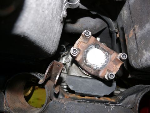 1976 Chevrolet Corvette - Undercarriage view shows a driveshaft U-joint, possibly a Spicer part, with surrounding mechanical components.