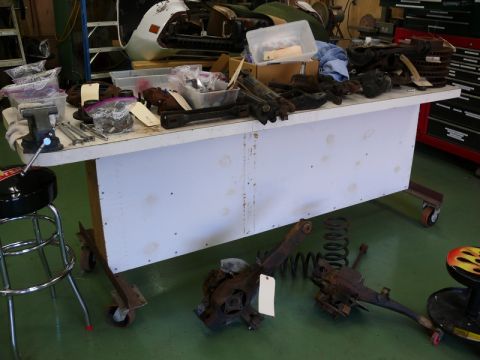 1976 Chevrolet Corvette - Workbench covered with automotive parts, possibly for a restoration project.