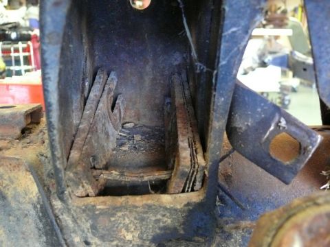 1976 Chevrolet Corvette - This image shows a close-up view of a corroded metal bracket, likely part of a vehicle's undercarriage or frame.