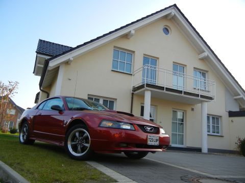 2003 Mercury Marauder - Red coupe with a hood scoop parked on a driveway in front of a house.