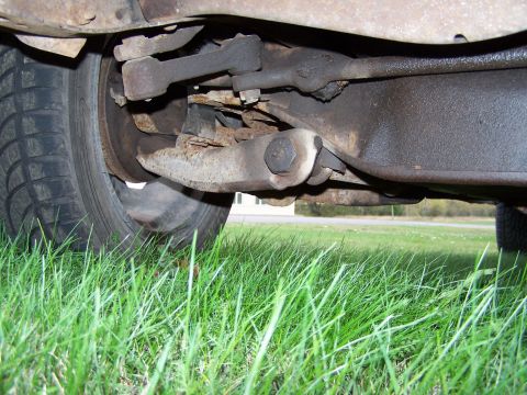 1969 Chevrolet C/K Pickup - Close-up view of the suspension and tire from underneath a vehicle.