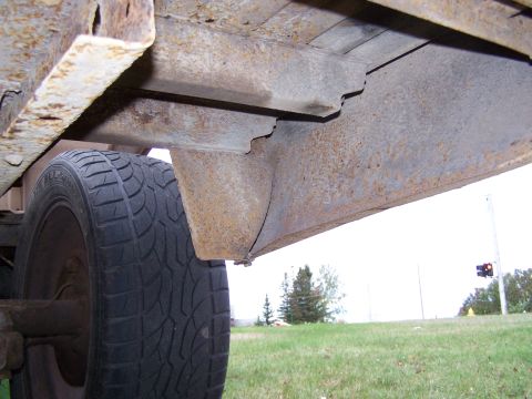 1969 Chevrolet C/K Pickup - Close-up view of the heavily rusted undercarriage and tire of a truck.