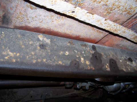 1969 Chevrolet C/K Pickup - Underside view of a heavily rusted truck frame, revealing significant corrosion and undercarriage parts.