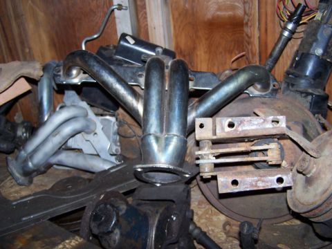 1969 Chevrolet C/K Pickup - Engine parts, including chrome exhaust headers, are stored in a workshop environment.