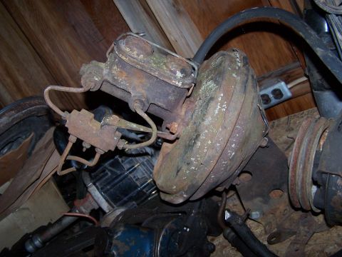 1969 Chevrolet C/K Pickup - Close-up of a corroded brake booster and master cylinder, showing brake lines and mounting hardware.
