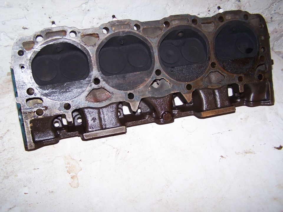 Engine cylinder head with four cylinders visible, showing valves and ports