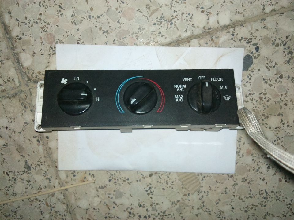 Climate control panel with knobs for fan speed, temperature, and air direction
