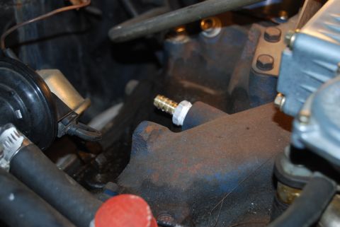 1975 Ford Ranchero - Close-up view of engine components, including a manifold and brass fitting.