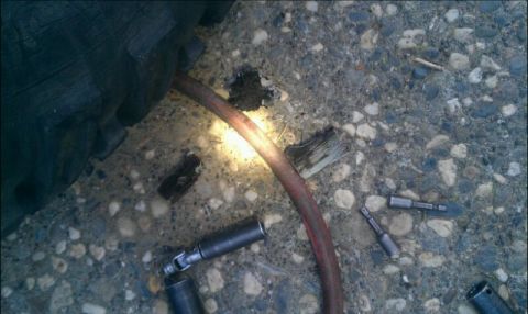 1986 Ford Bronco - Tools and a tire are scattered on the ground, suggesting a repair in progress.