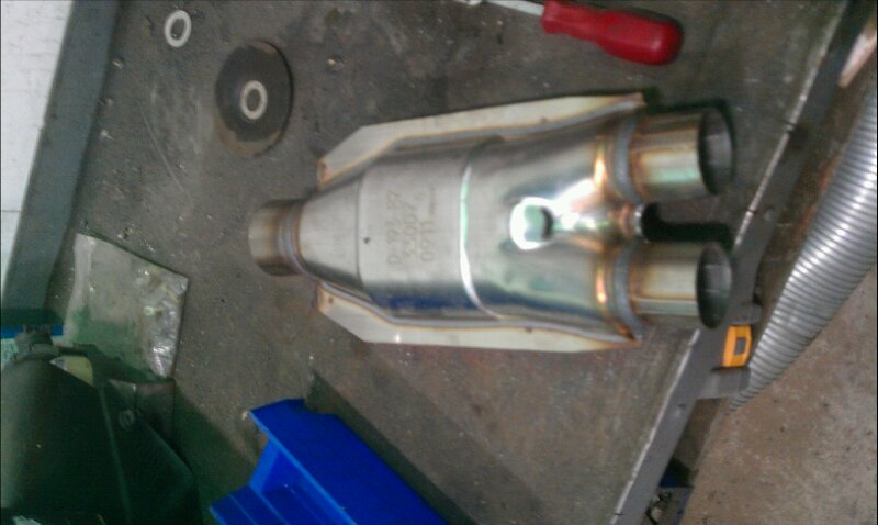 Catalytic converter with visible part numbers on a workbench