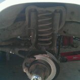 1986 Ford Bronco - Close-up view of a vehicle's front suspension and brake components during repair.