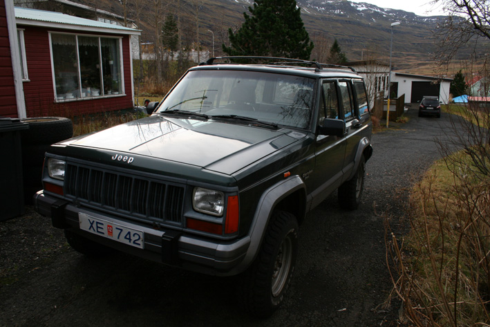 1992 Jeep Cherokee XJ parked on gravel driveway, dark green paint, license plate XE 742