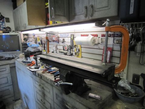 2008 Jeep Wrangler - A cluttered workbench displays a metal lathe, various tools, and a vintage television monitor.