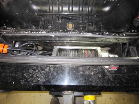 2008 Jeep Wrangler - A Warn winch is installed in the rear of a vehicle, with cables and wiring visible.