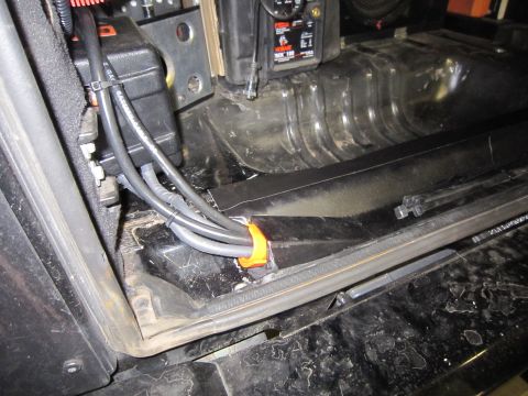 2008 Jeep Wrangler - Close-up view of wiring and a battery box, possibly in a vehicle's interior or cargo area.